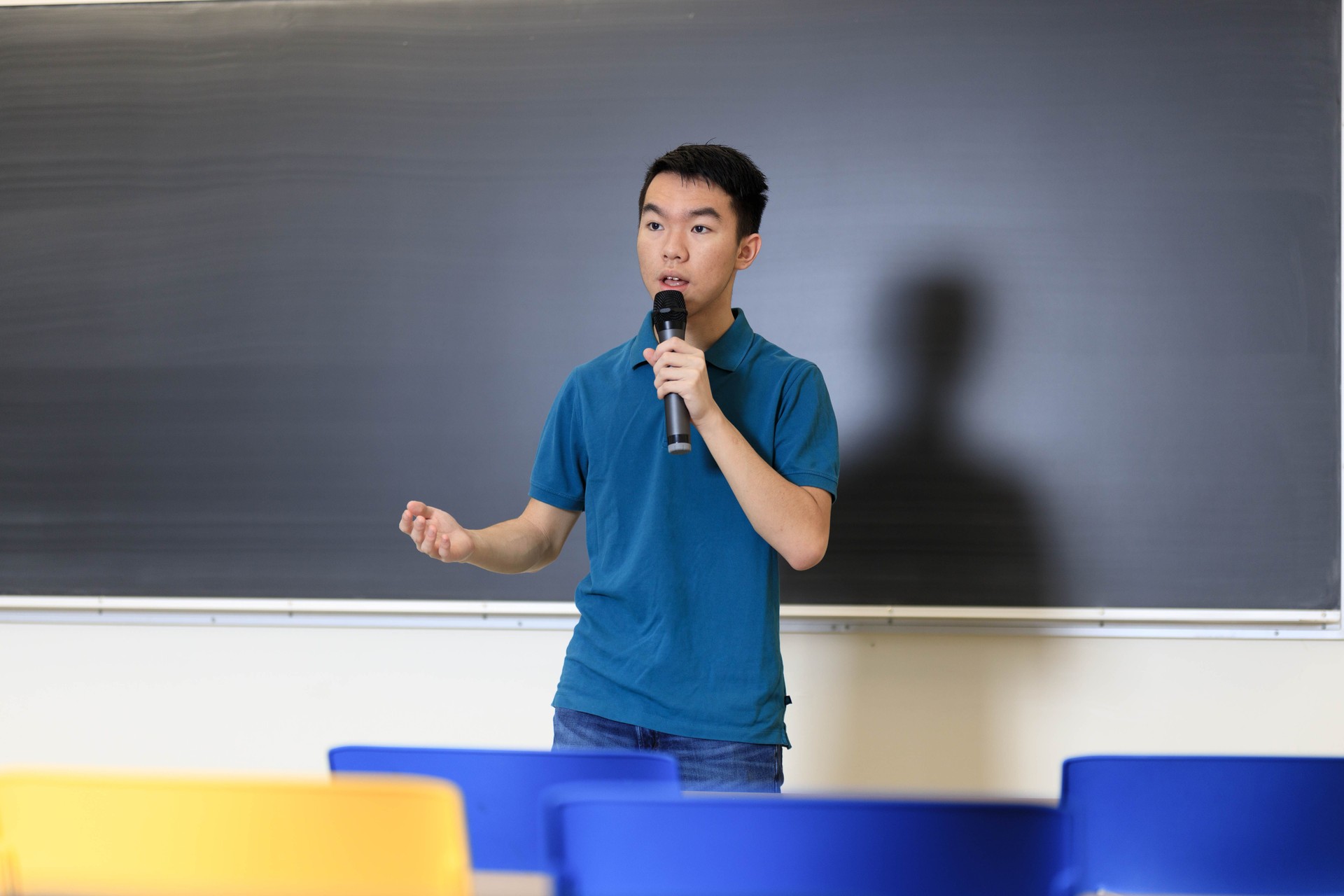 Teenage boy giving a presentation speech in class